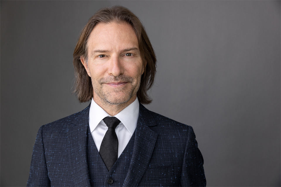 Eric Whitacre in a suit looking at the camera. 